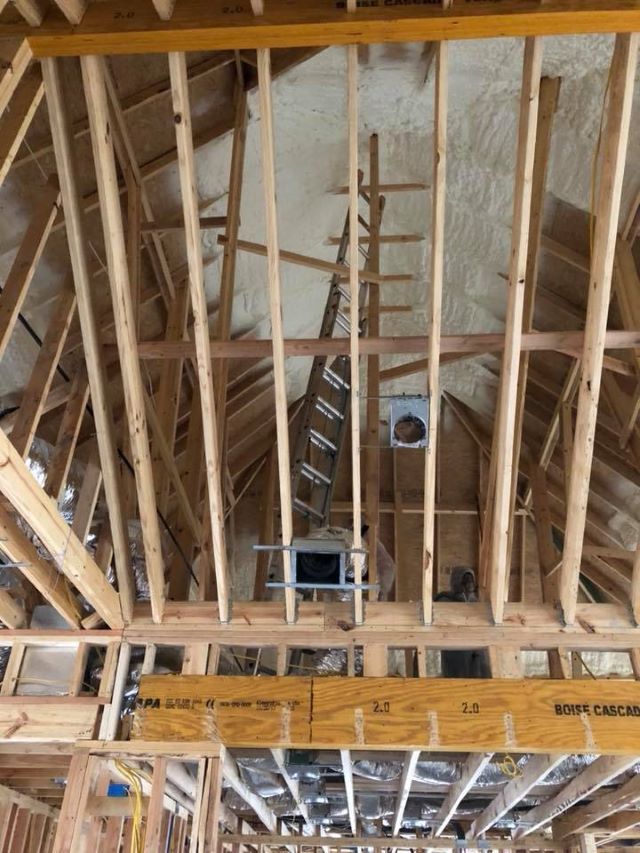 Vaulted attic of a home under construction with insulation applied at the roof deck